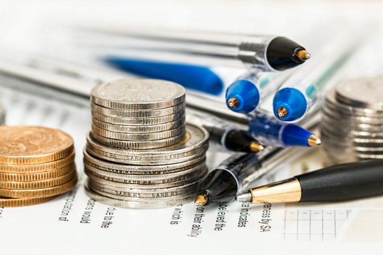 coins and pens on a types document