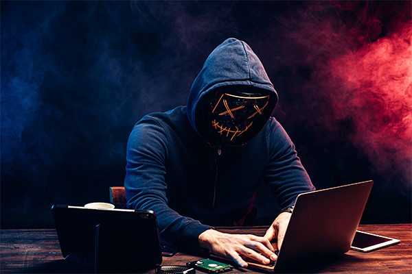 man with mask at laptop